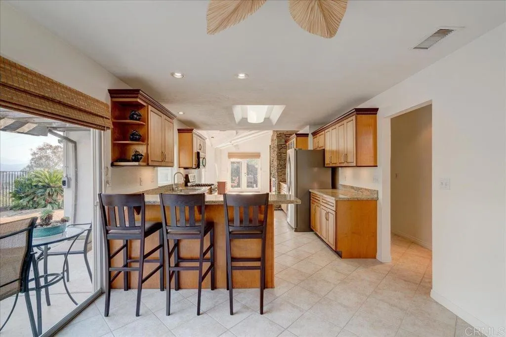 15753 Lyons Valley Road Jamul, CA 91935 - Photo 15 of 47 a dining room with stainless steel appliances a table and chairs