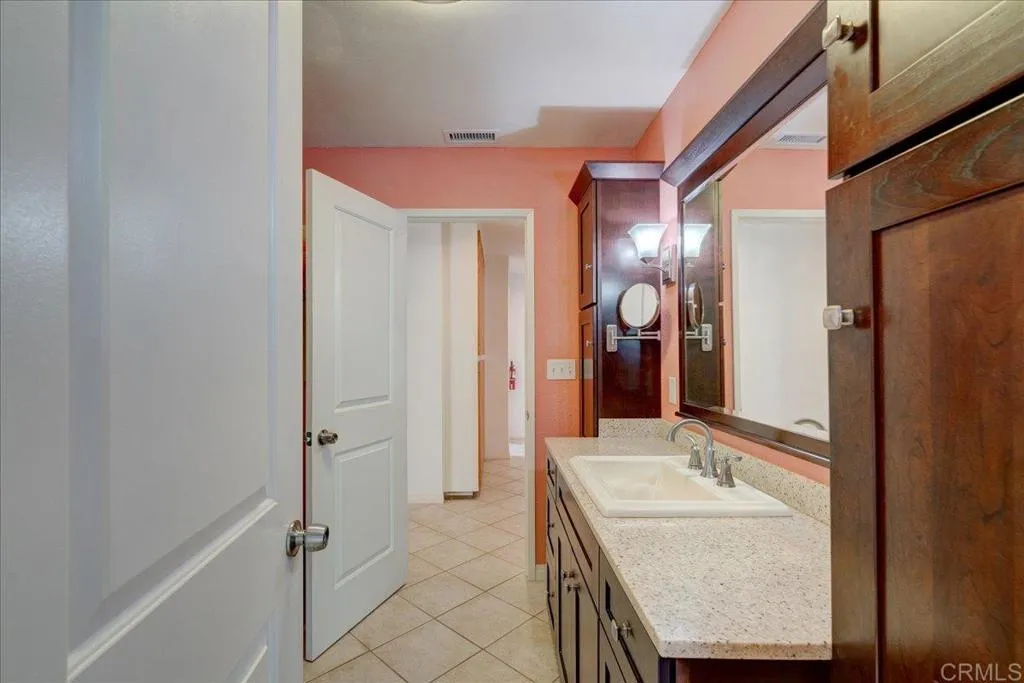 15753 Lyons Valley Road Jamul, CA 91935 - Photo 23 of 47 a bathroom with a granite countertop sink and a mirror