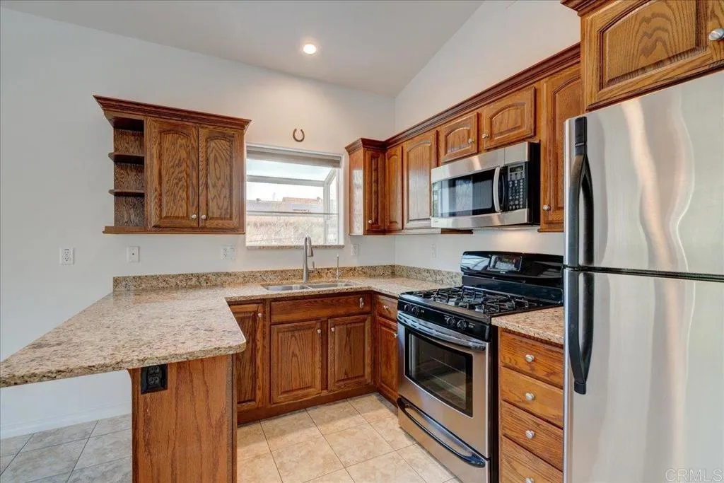 15753 Lyons Valley Road Jamul, CA 91935 - Photo 28 of 47 a kitchen with stainless steel appliances granite countertop a stove a sink dishwasher and a refrigerator