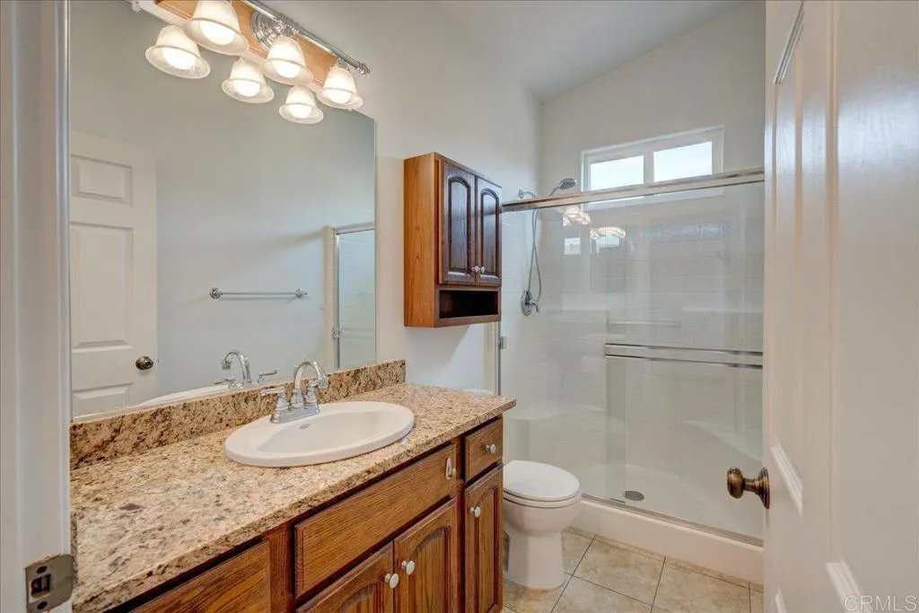 15753 Lyons Valley Road Jamul, CA 91935 - Photo 30 of 47 a bathroom with a granite countertop sink toilet and shower