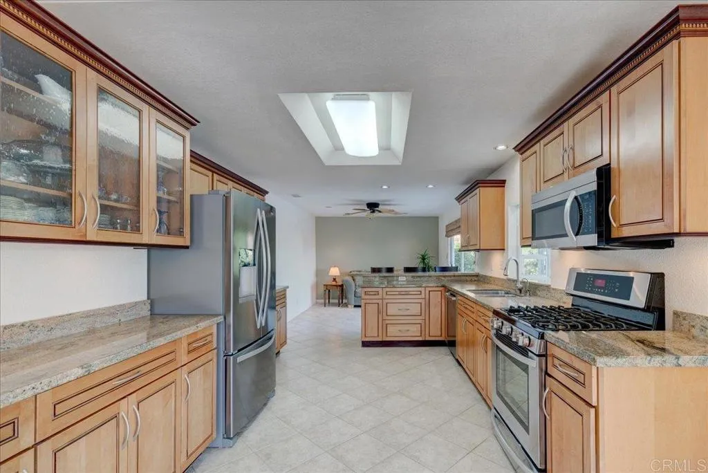 15753 Lyons Valley Road Jamul, CA 91935 - Photo 9 of 47 a large kitchen with stainless steel appliances granite countertop a stove top oven a refrigerator a sink and dishwasher