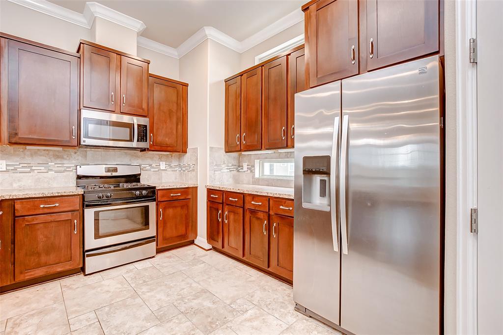 a kitchen with stainless steel appliances granite countertop a refrigerator and a stove top oven