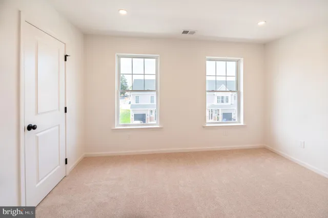 an empty room with windows and closet