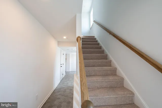 a view of staircase with white walls and white door
