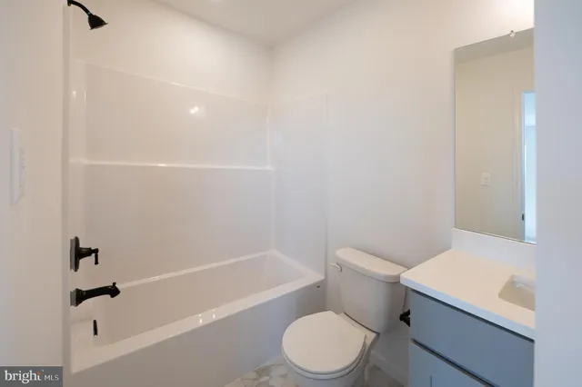 a white toilet and tub sitting next to a bathroom sink