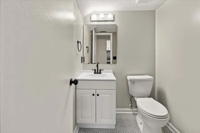 a bathroom with a toilet a sink and mirror