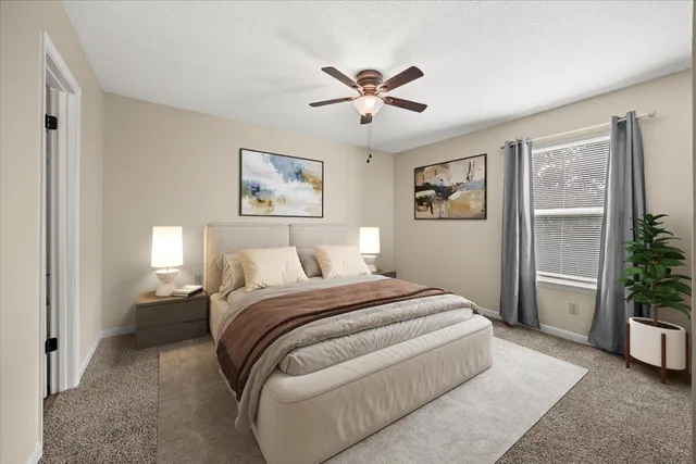 a spacious bedroom with a bed and a painting on the wall