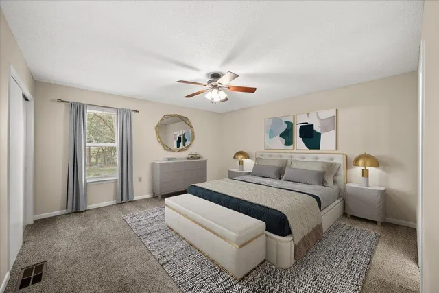 a bedroom with a large bed and a chandelier