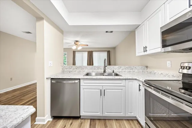 a kitchen with stainless steel appliances granite countertop a sink and cabinets