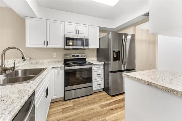a kitchen with stainless steel appliances granite countertop a sink stove and refrigerator
