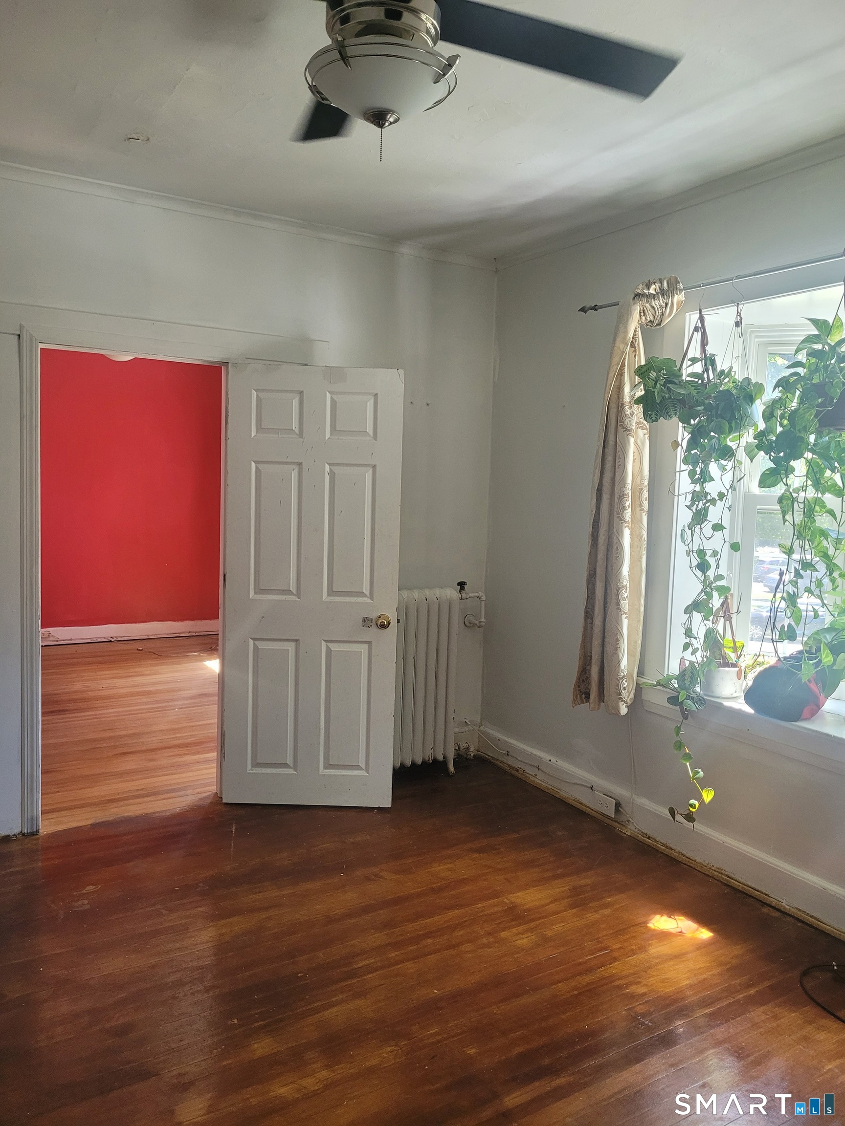 606 Wilmot Avenue, Unit 4 Bridgeport, CT 06607 - Photo 6 of 16 an empty room with wooden floor and windows