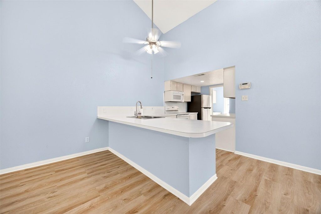 17 April Point Drive North Conroe, TX 77356 - Photo 19 of 42 a kitchen with a sink cabinets and wooden floor