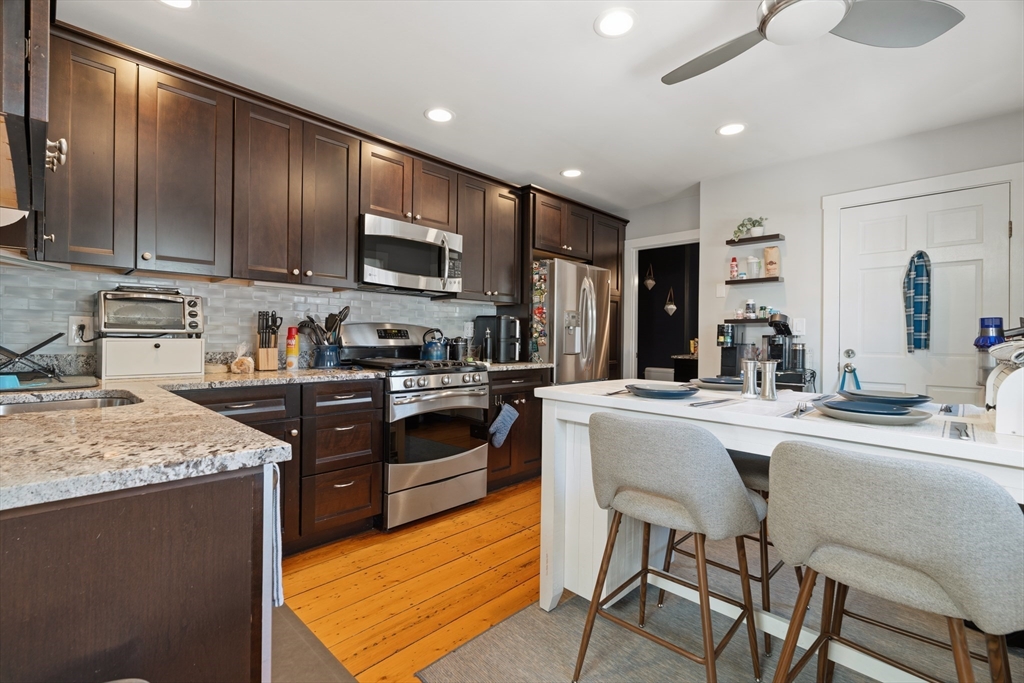 33 Mystic Street, Unit 3 Boston, MA 02129 - Photo 9 of 21 a kitchen with stainless steel appliances granite countertop wooden cabinets a stove top oven a sink and dishwasher