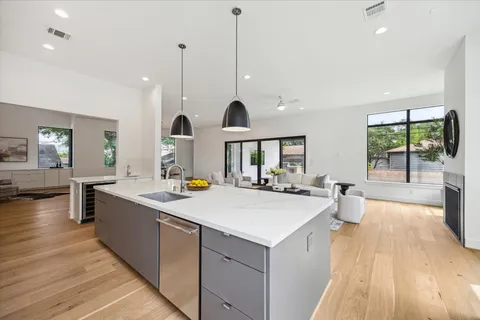a living room with furniture kitchen view and a large window