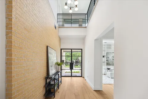 a view of a hallway with wooden floor and staircase