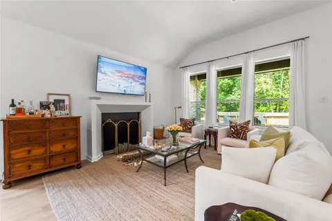 a living room with furniture a fireplace and a floor to ceiling window