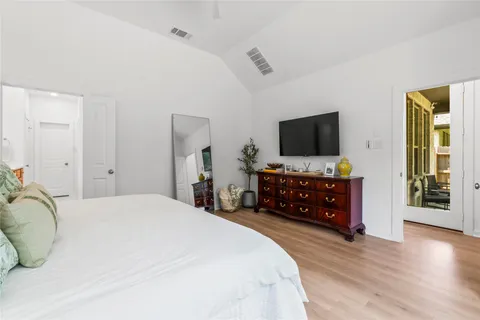 a spacious bedroom with a bed and a flat screen tv