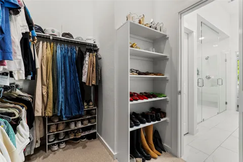 a view of walk in closet with clothes and shoes