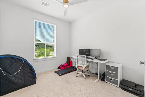 a view of a workspace with furniture and a window