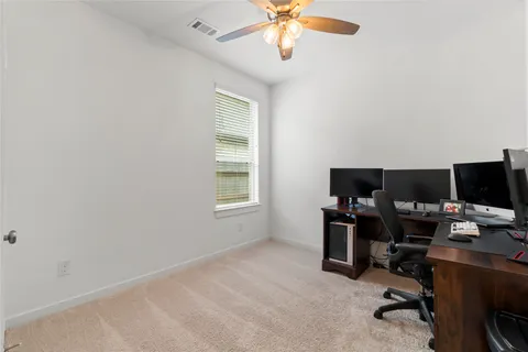 a view of a workspace with furniture and a window