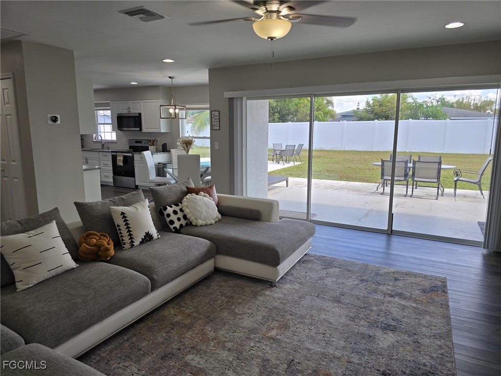 112 Rowland Road Lehigh Acres, FL 33936 - Photo 11 of 31 a living room with furniture and a floor to ceiling window