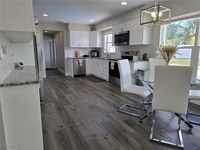 a kitchen with stainless steel appliances granite countertop a refrigerator sink and microwave