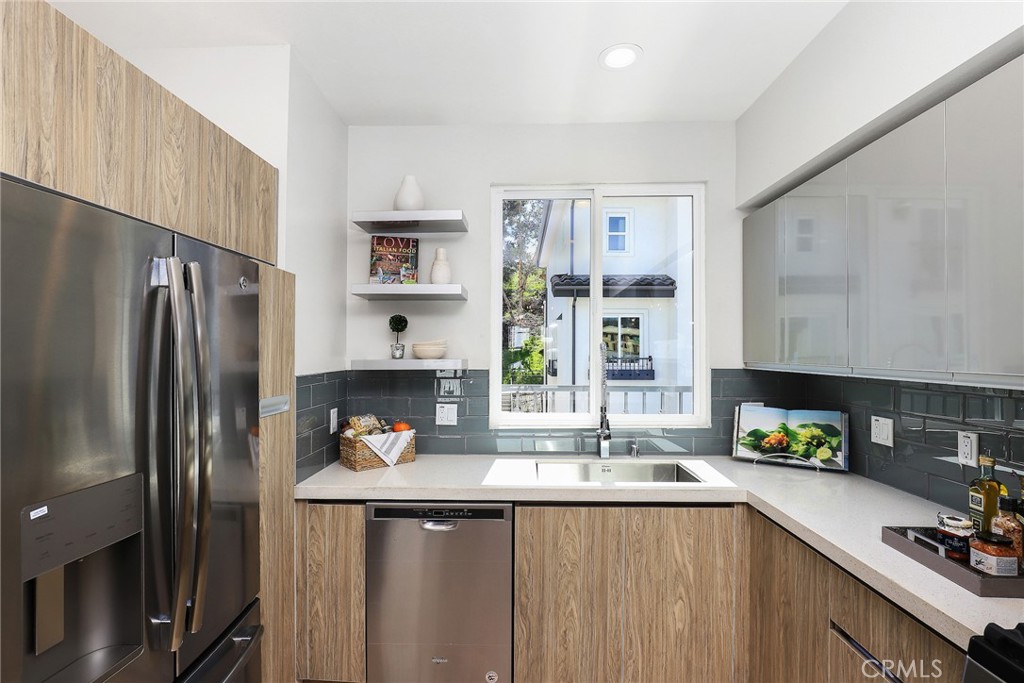24 Spyglass Avenue Phillips Ranch, CA 91766 - Photo 16 of 63 a kitchen with stainless steel appliances a sink a refrigerator and a counter space