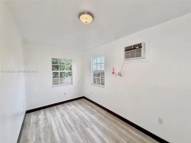 a view of a room with wooden floor and white walls