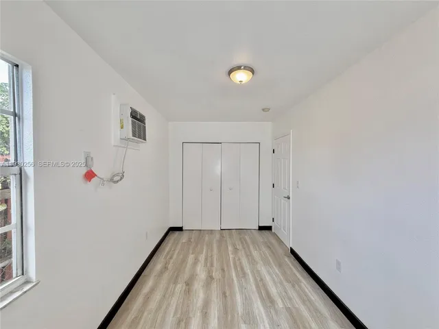 a view of a room with wooden floor and white walls