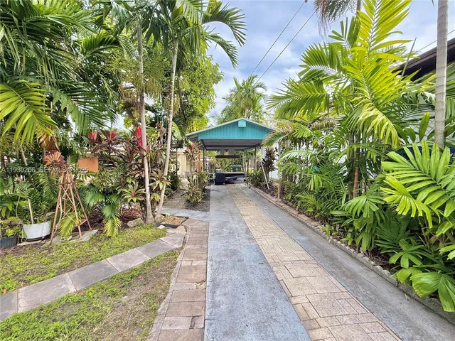 a backyard of a house with table and chairs plants and trees