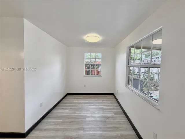 a kitchen with white cabinets and chandelier