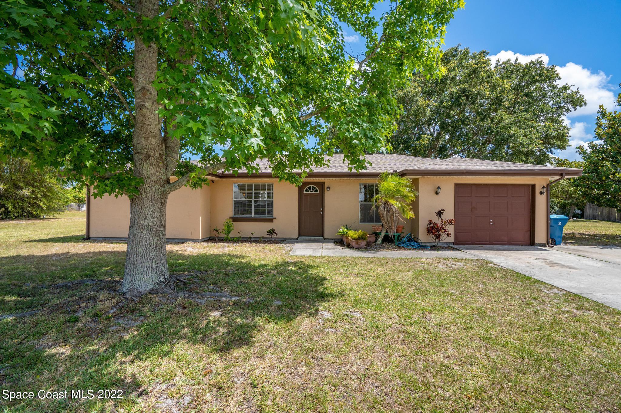 1148 Newbern Street Northeast Palm Bay, FL 32905 - Photo 1 of 38 a view of a house with backyard and trees