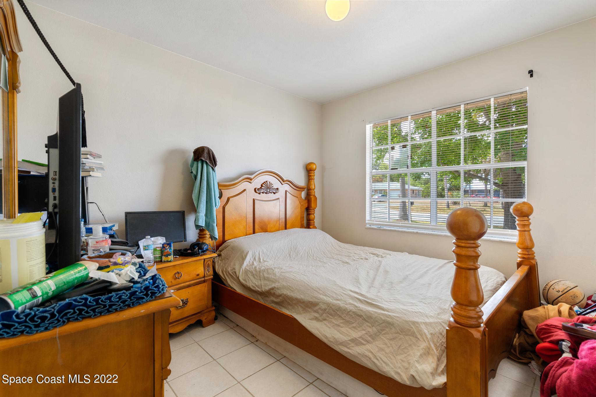 1148 Newbern Street Northeast Palm Bay, FL 32905 - Photo 12 of 38 a bedroom with a bed and large windows