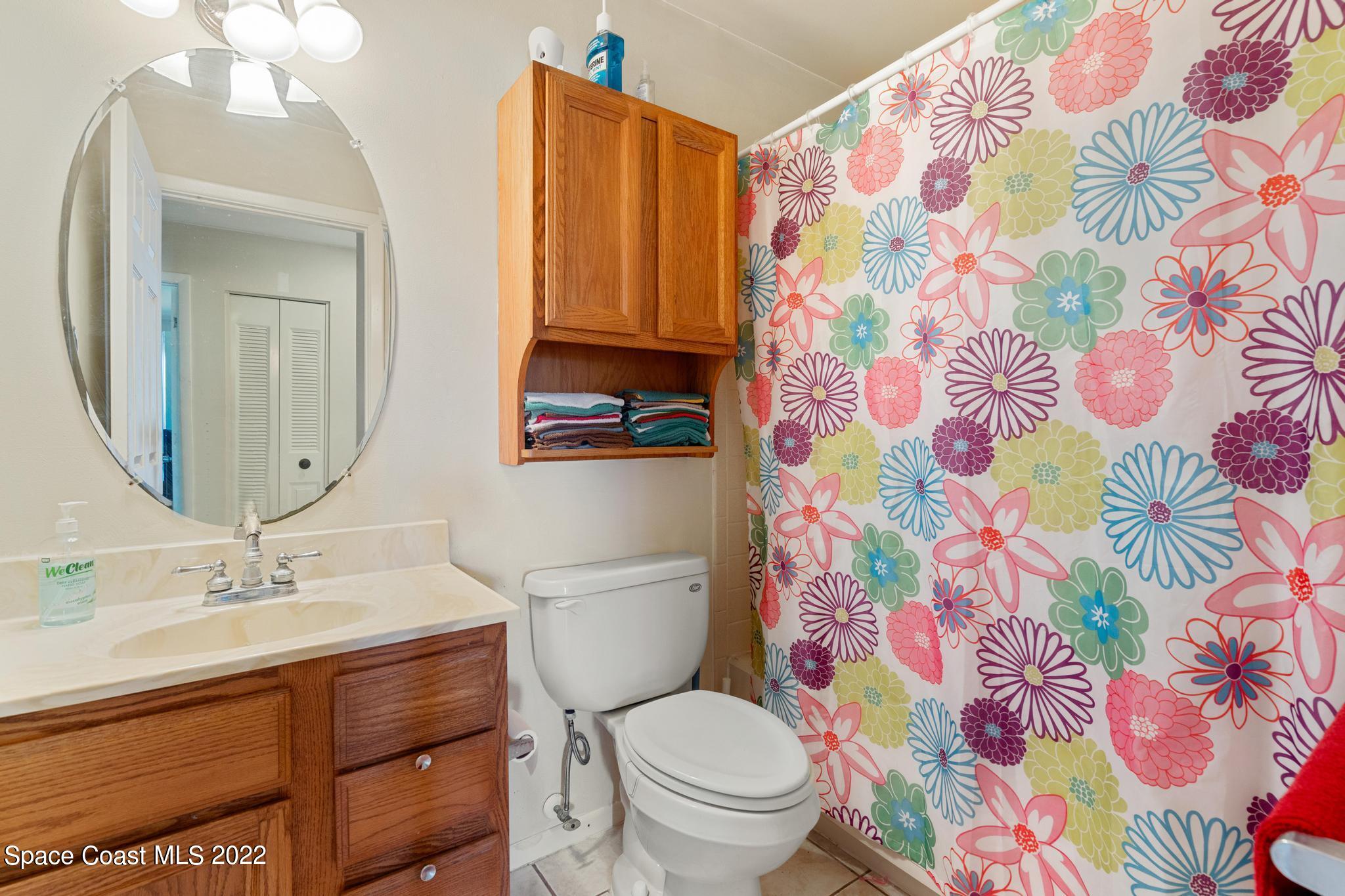 1148 Newbern Street Northeast Palm Bay, FL 32905 - Photo 13 of 38 a bathroom with a toilet sink and mirror