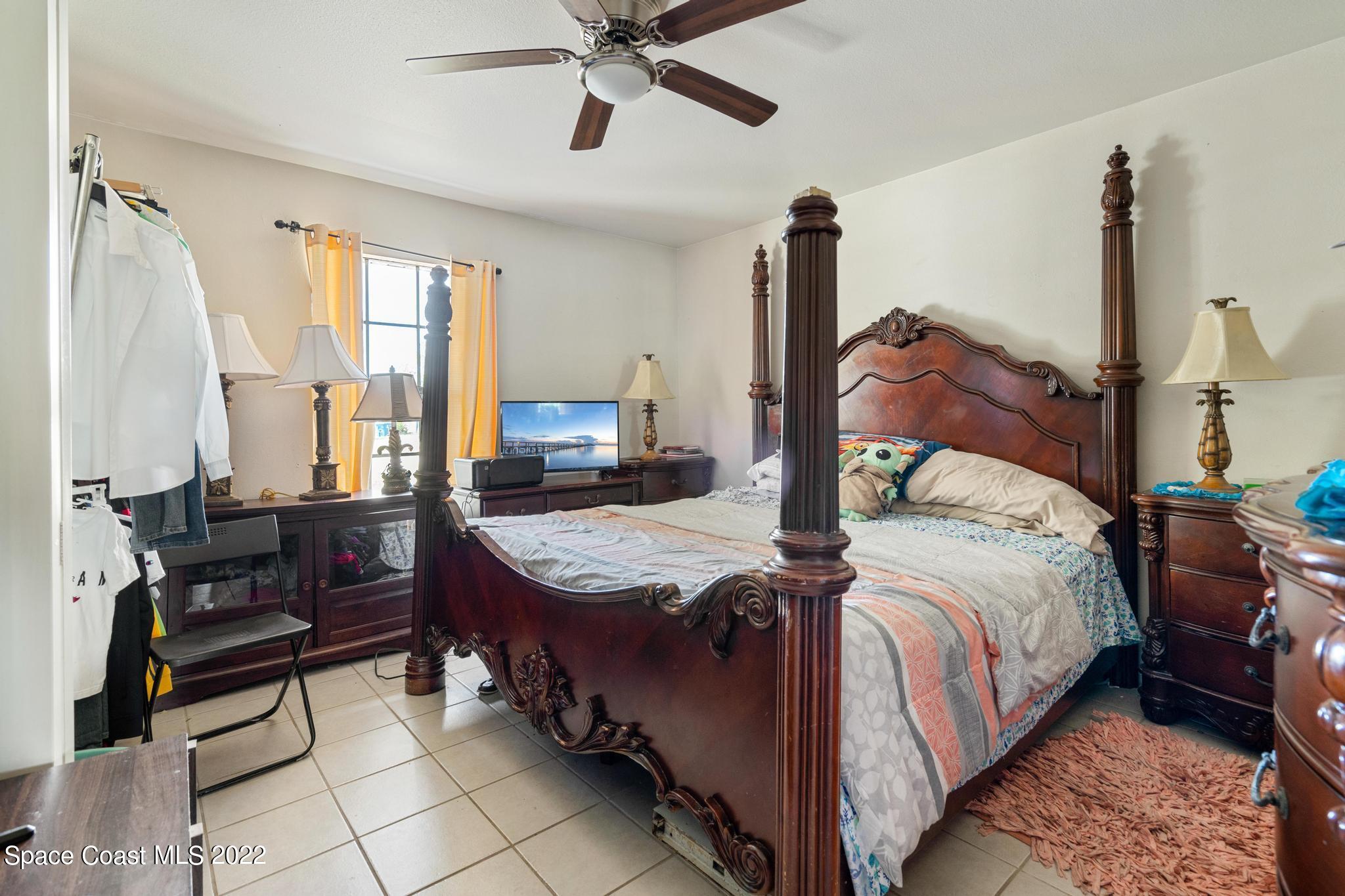 1148 Newbern Street Northeast Palm Bay, FL 32905 - Photo 14 of 38 a bed room with a bed and dresser