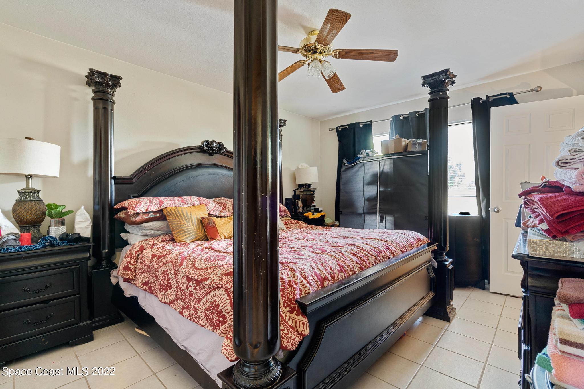 1148 Newbern Street Northeast Palm Bay, FL 32905 - Photo 15 of 38 a bed room with a bed and a lamp