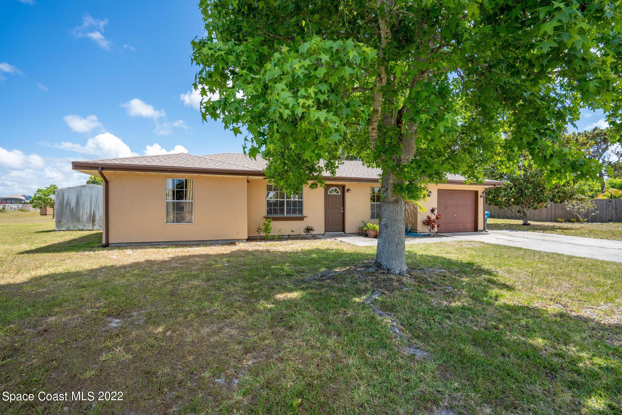 1148 Newbern Street Northeast Palm Bay, FL 32905 - Photo 2 of 38 a house with a tree in front of it