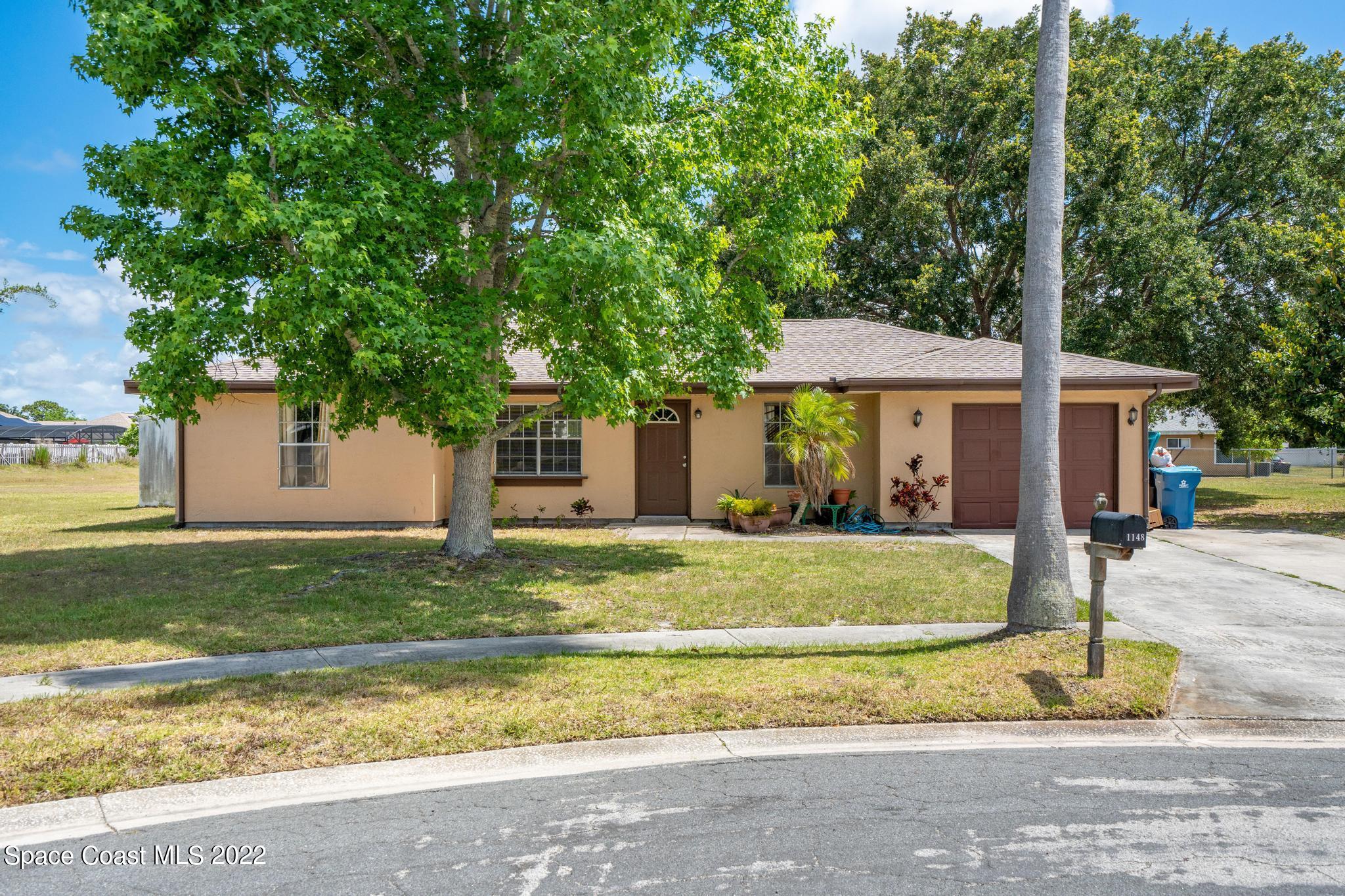 1148 Newbern Street Northeast Palm Bay, FL 32905 - Photo 20 of 38 a view of a house with a yard and tree s