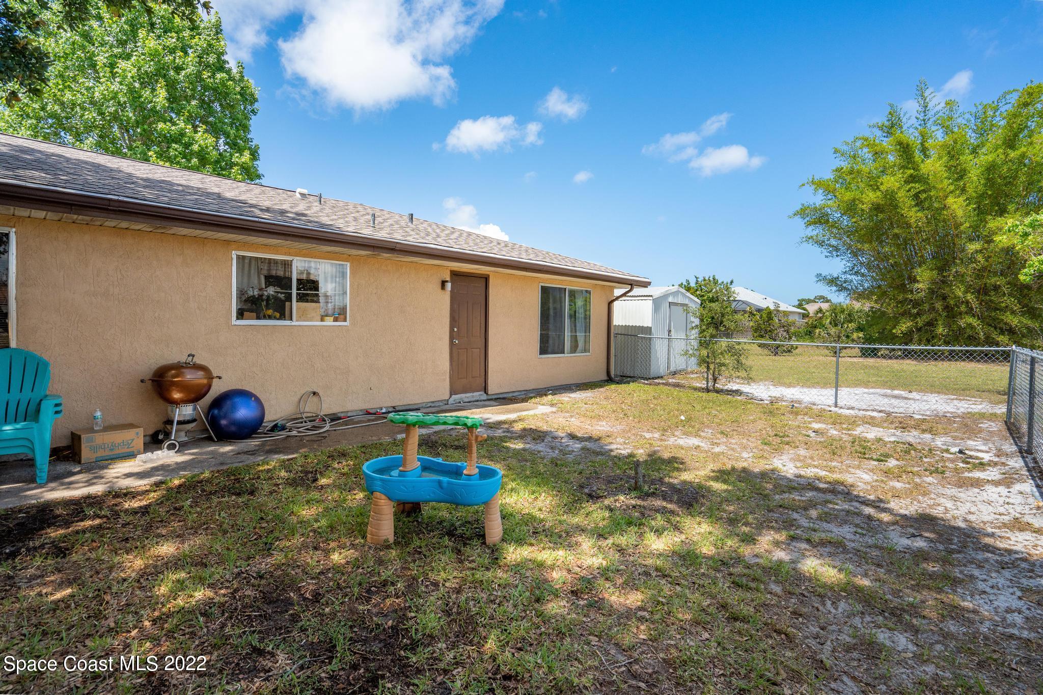 1148 Newbern Street Northeast Palm Bay, FL 32905 - Photo 22 of 38 a backyard of a house with table and chairs