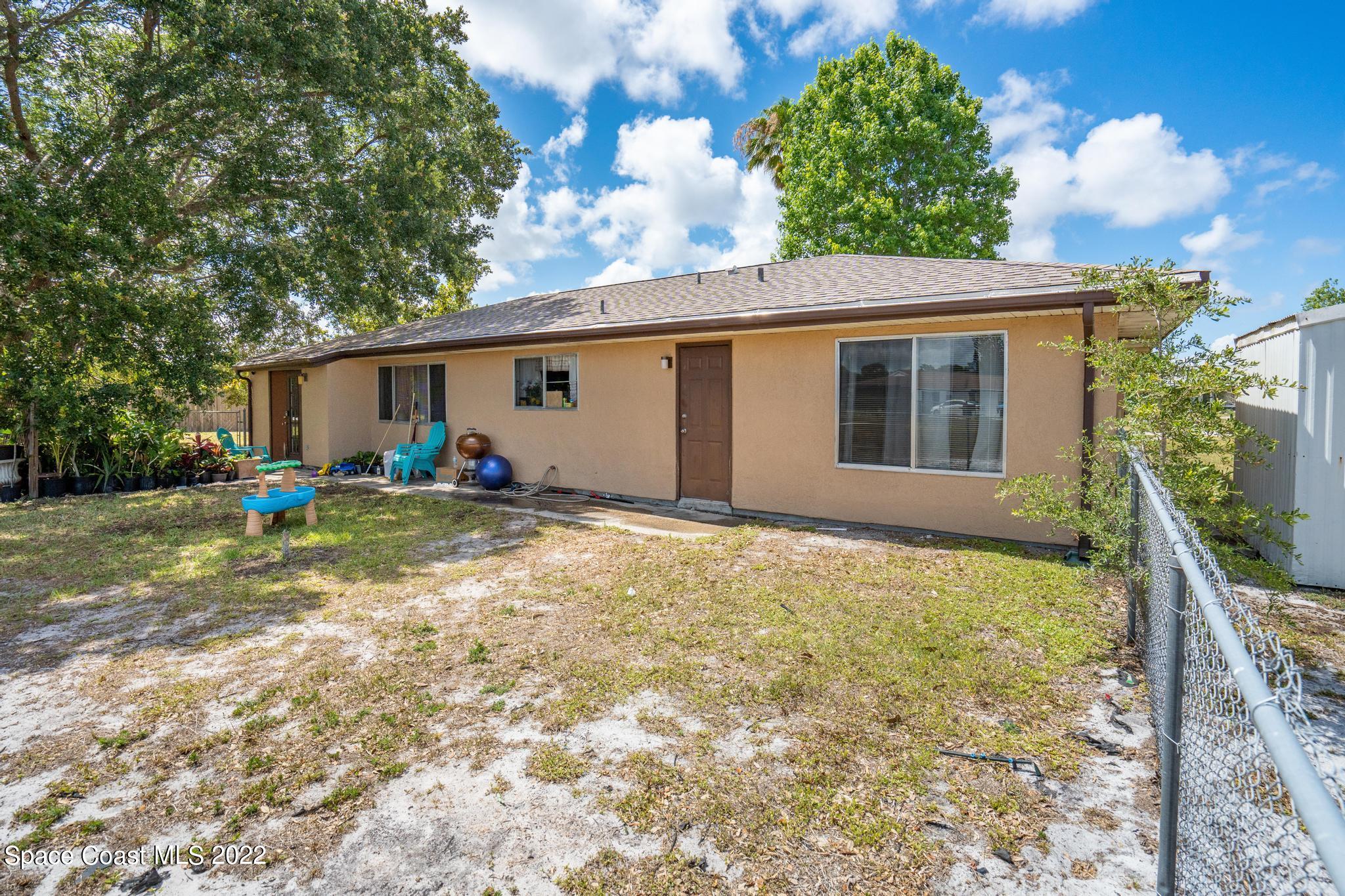 1148 Newbern Street Northeast Palm Bay, FL 32905 - Photo 25 of 38 a backyard of a house with table and chairs