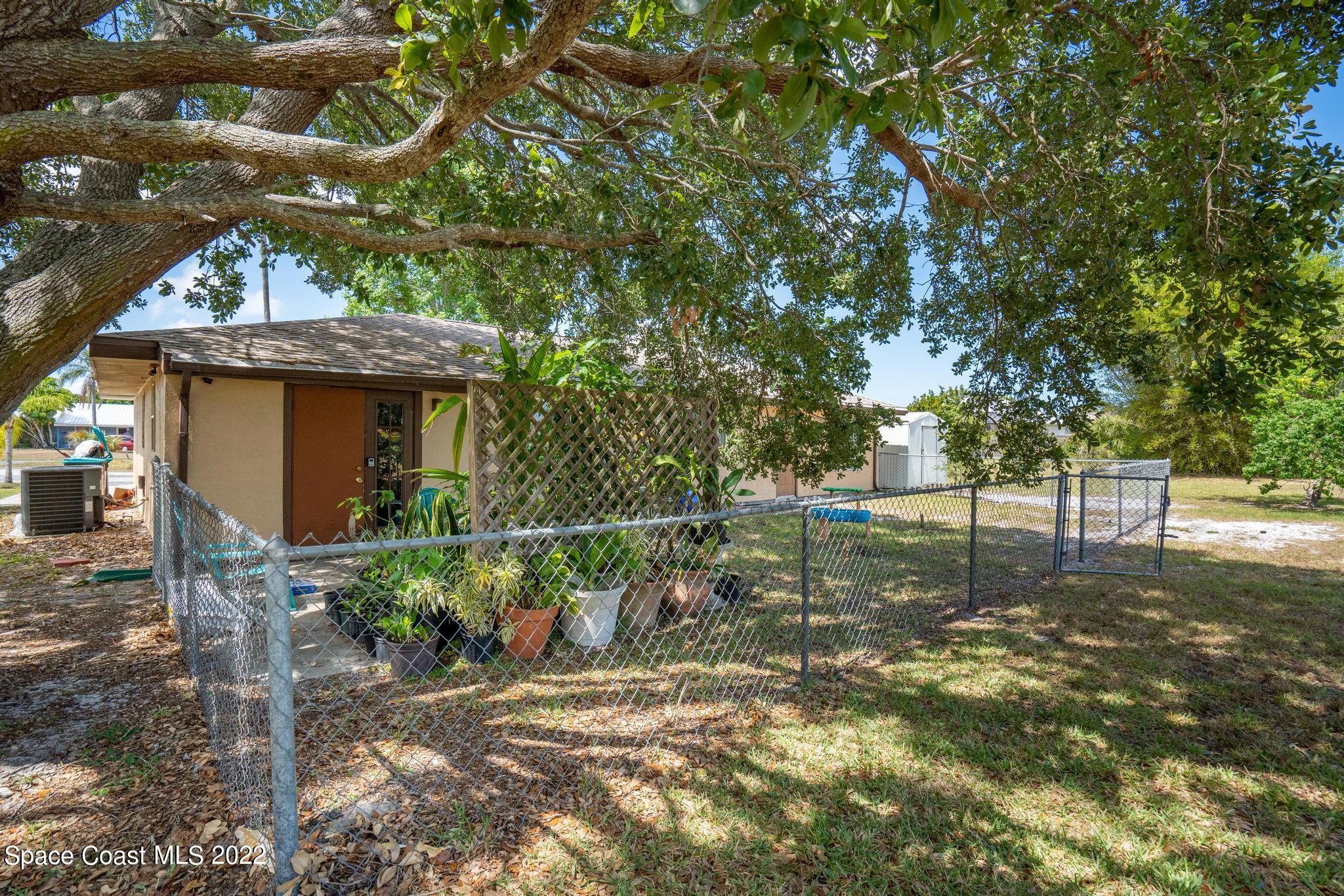 1148 Newbern Street Northeast Palm Bay, FL 32905 - Photo 26 of 38 a backyard of a house with lots of green space