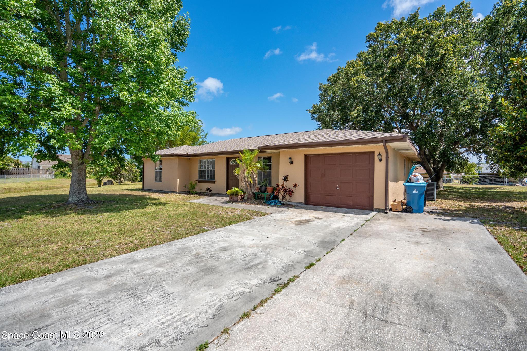 1148 Newbern Street Northeast Palm Bay, FL 32905 - Photo 3 of 38 a view of a house with a yard and large tree