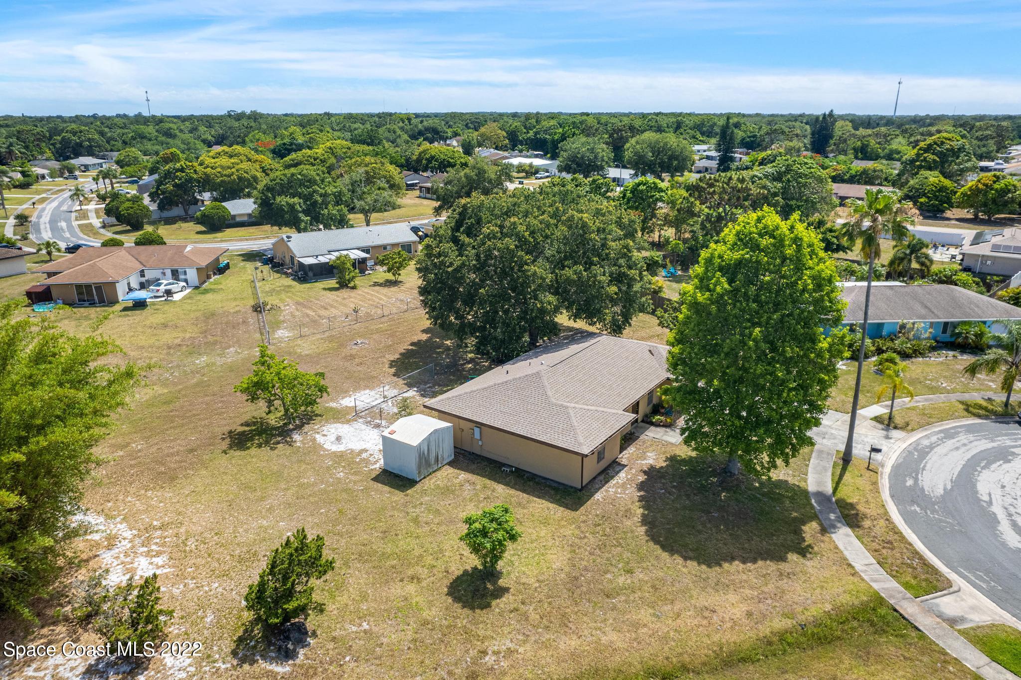 1148 Newbern Street Northeast Palm Bay, FL 32905 - Photo 31 of 38 an aerial view of a house with a yard and lake view