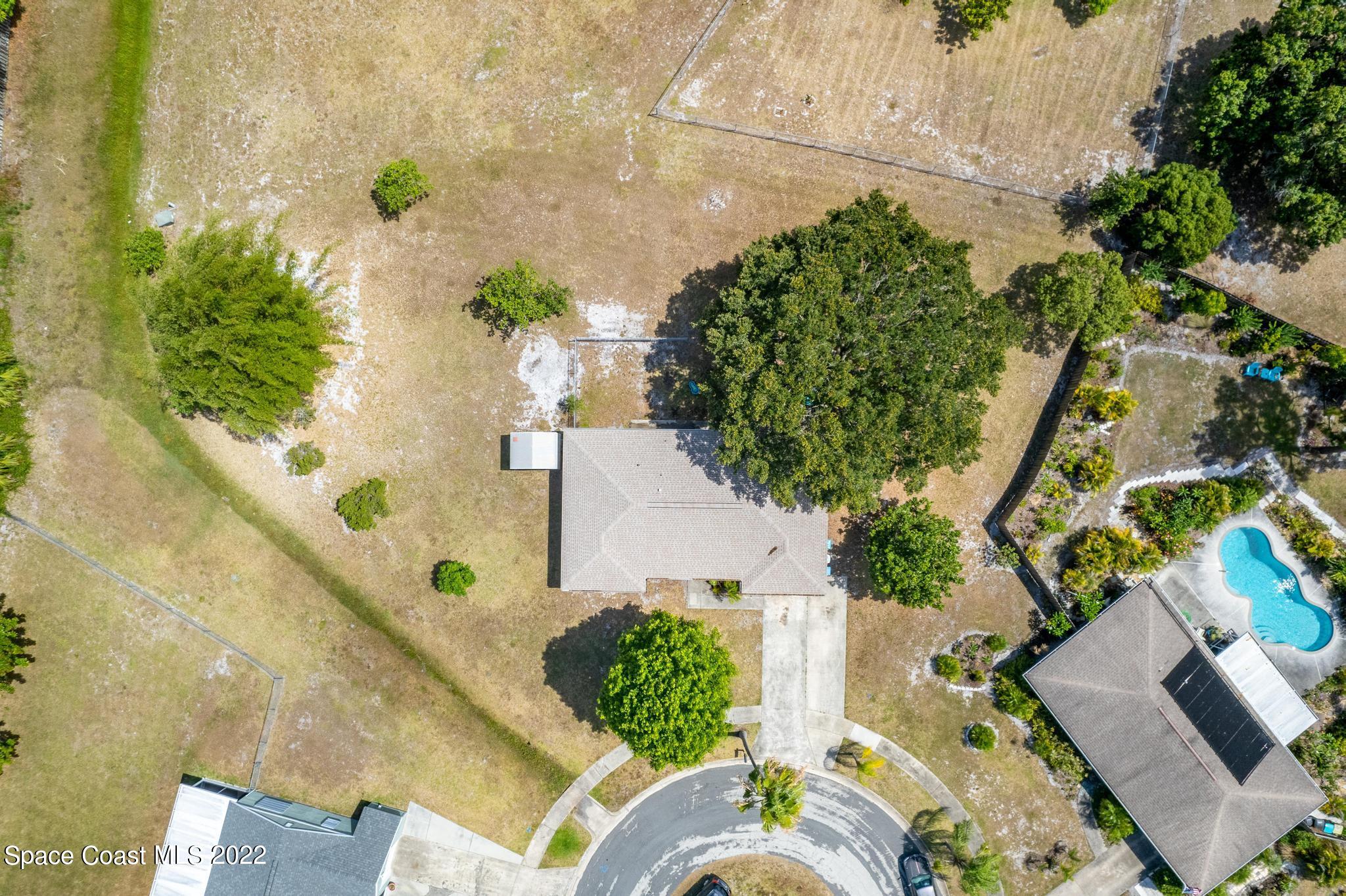 1148 Newbern Street Northeast Palm Bay, FL 32905 - Photo 34 of 38 an aerial view of a house with a yard and wooden fence