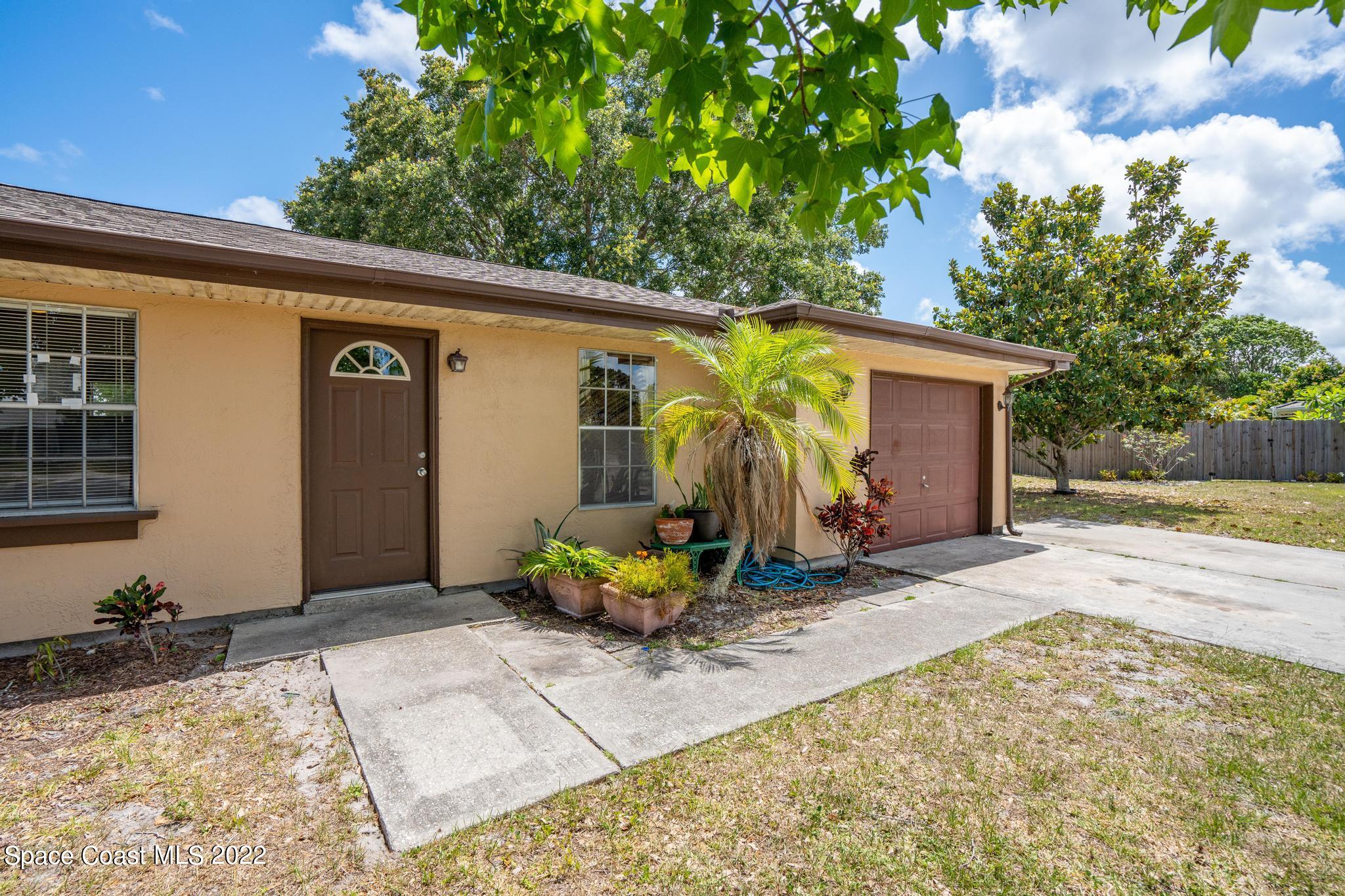 1148 Newbern Street Northeast Palm Bay, FL 32905 - Photo 4 of 38 a view of backyard with wheel chair and potted plants