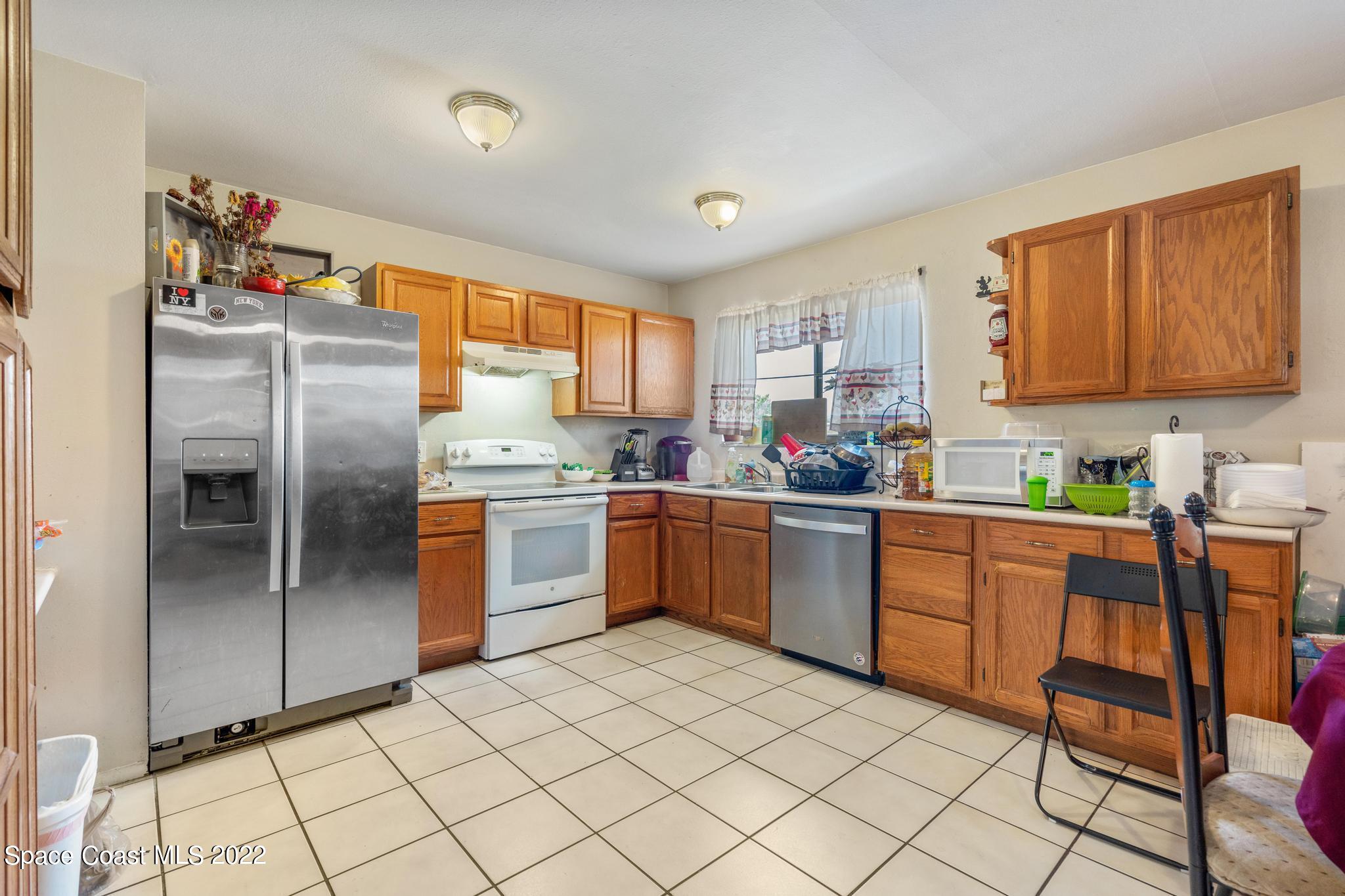 1148 Newbern Street Northeast Palm Bay, FL 32905 - Photo 8 of 38 a kitchen with granite countertop stainless steel appliances a sink and cabinets