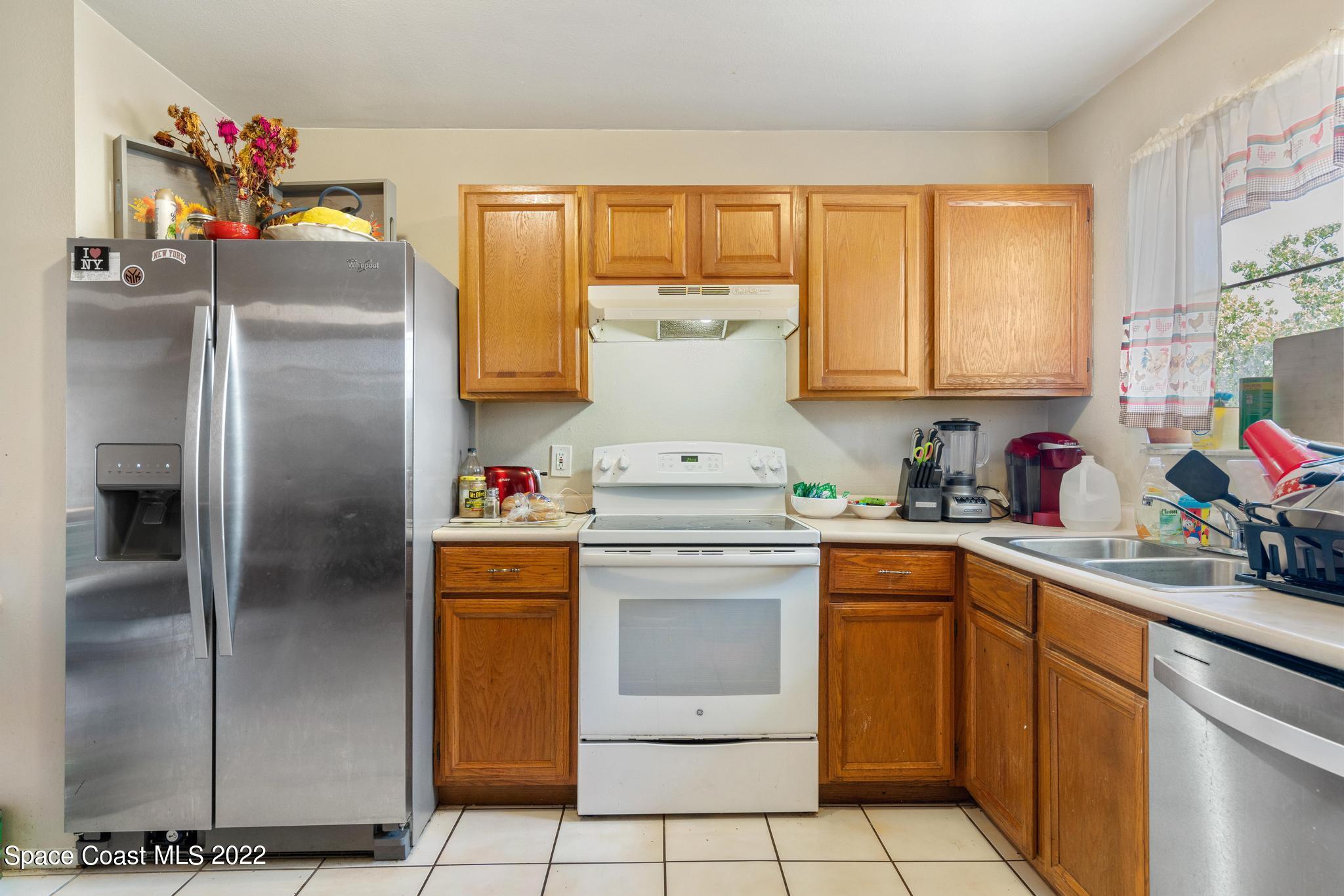 1148 Newbern Street Northeast Palm Bay, FL 32905 - Photo 9 of 38 a kitchen with a refrigerator and window