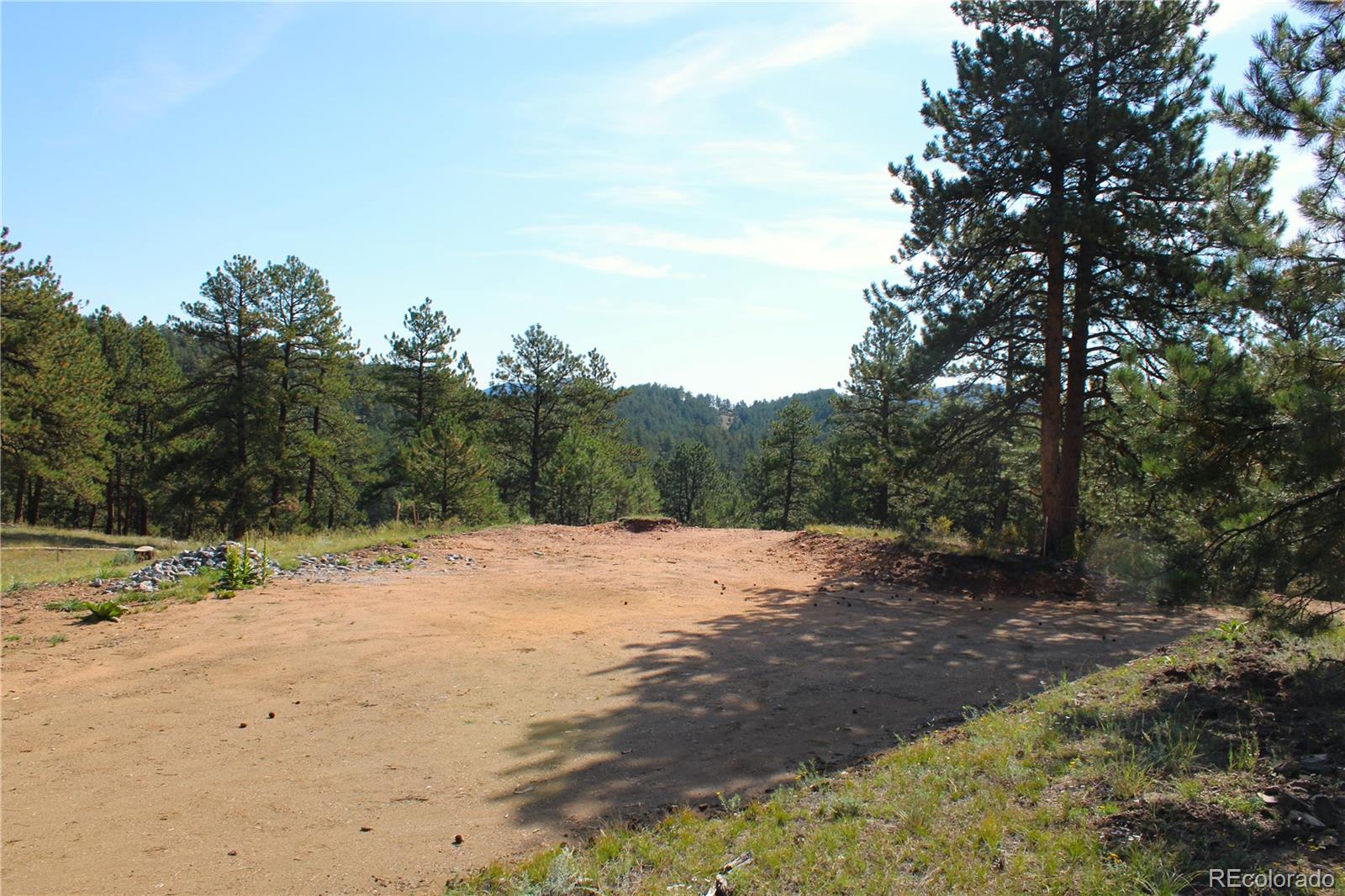 2414 Legacy Ranch Road Evergreen, CO 80439 - Photo 7 of 16 a wooden bench with view of trees