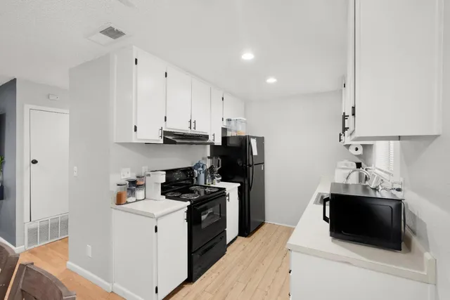a kitchen with a sink and white cabinets