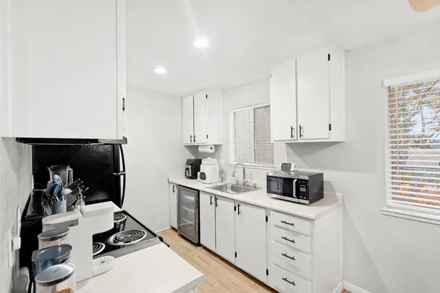 a kitchen with cabinets appliances and a window